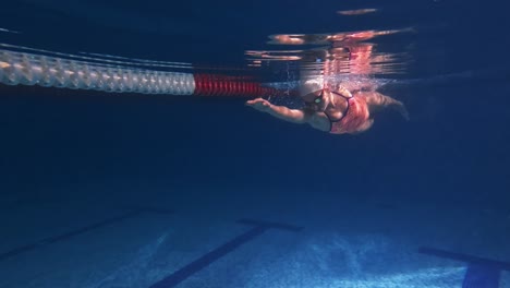 woman swimming underwater in pool