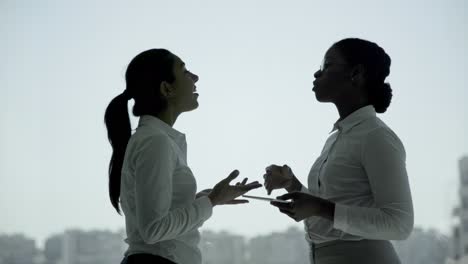 smiling young businesswomen with digital tablet