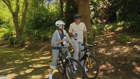 old man and woman drinking and biking