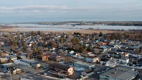 lenta carretilla aérea izquierda tiro de la ciudad cubierta de nieve de thurso quebec canadá con el río congelado de ottawa visible en el fondo en un día de invierno