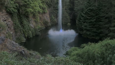 A-single-stream-of-water-shoots-from-a-secluded-lake