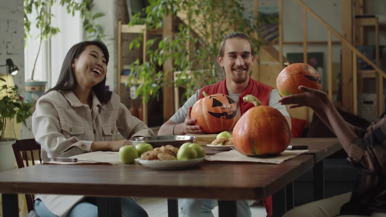 젊은 여자들이 손으로 만든 호박을 교환하고 이야기합니다.