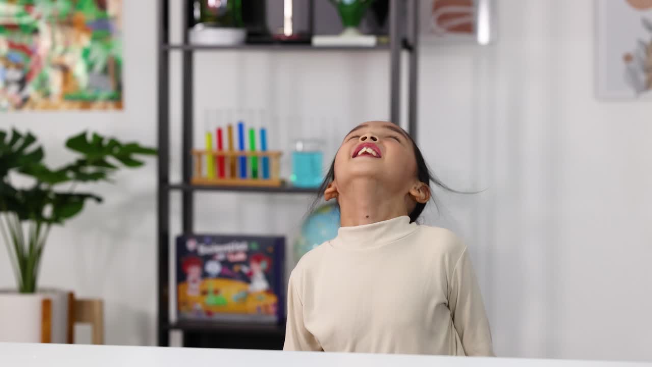 Happy Young Girl Laughing and Putting on a Lab Coat