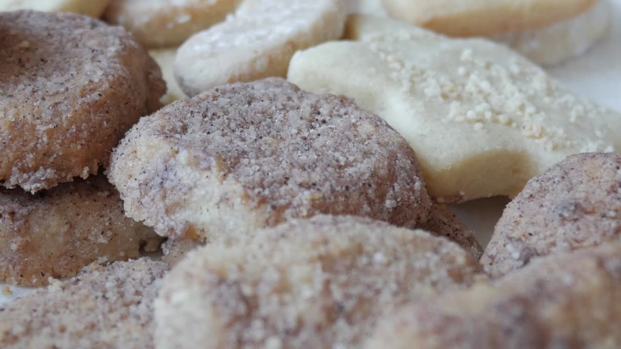 A left-to-right pan of homemade German Butterplätzchen, showcasing their powdered sugar topping and crumbly texture, capturing an authentic taste of German tradition.