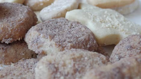 a left-to-right pan of homemade german butterplätzchen, showcasing their powdered sugar topping and crumbly texture, capturing an authentic taste of german tradition.