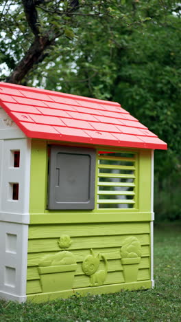 barefoot toddler runs up to his playhouse outdoors. kid enters the house closing the door. vertical video.