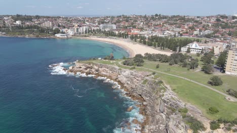 Ocean-Waves-Crashing-At-Dolphins-Point-Peninsula-With-Coogee-Beach-In-Background---Bondi-To-Coogee-Coastal-Walk-In-Summer-In-NSW,-Australia