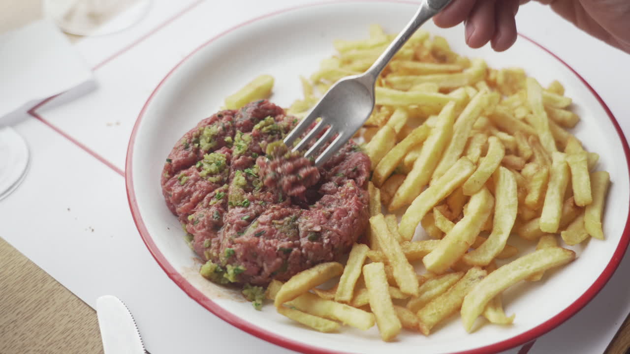 знаменитый французский стейк татар с картошкой фри вилка играет с мясом