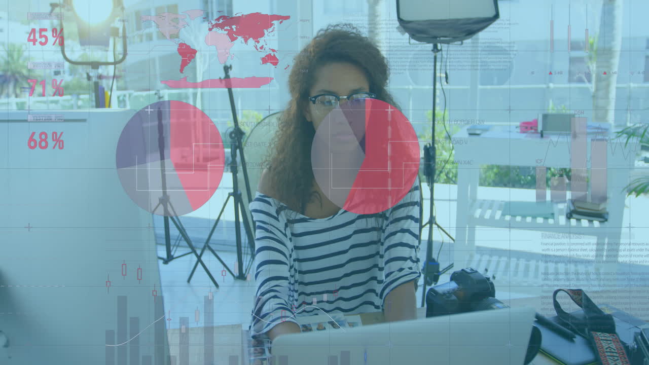 animación de la interfaz infográfica moviéndose sobre una mujer de negocios biracial trabajando en una computadora portátil en el escritorio