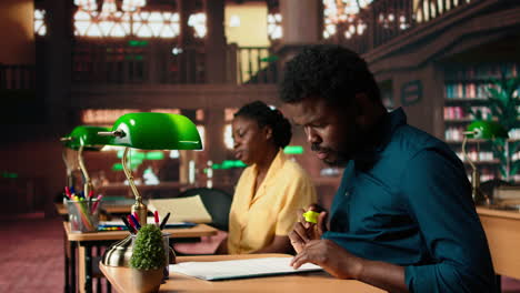 black university student highlighting relevant phrases to learn the summary