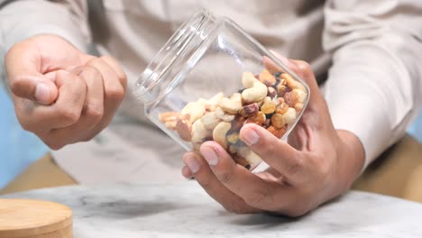 man holding a jar of mixed nuts