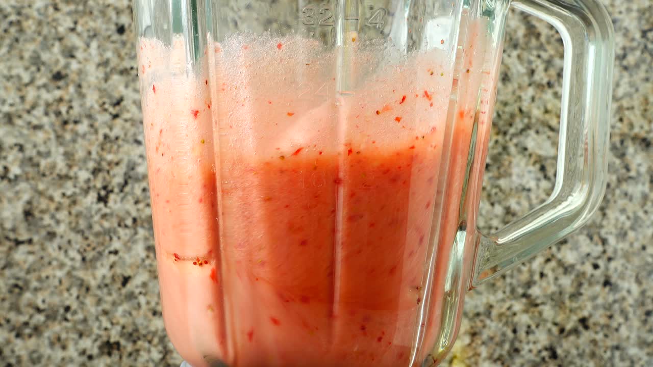 Preparazione di un cocktail nel frullatore con mele, banane e fragole. Riprese in cucina.