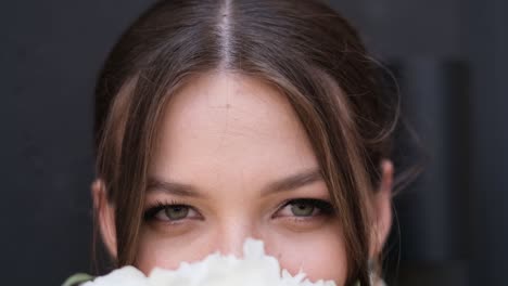 close up of loving eyes of beautiful bride on gray background close up of loving eyes of beautiful bride on gray background brides bouquet of white flowers