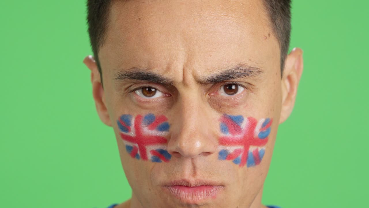 Serious man with a british flag painted on the face