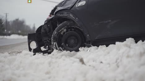 damage to a crashed car on the side of a snowy road