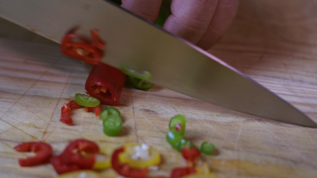 cocine pimiento rojo y pimiento verde en una tabla de cortar de madera