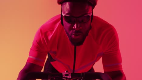 Video-of-focused-african-american-male-cyclist-riding-on-neon-orange-lightning