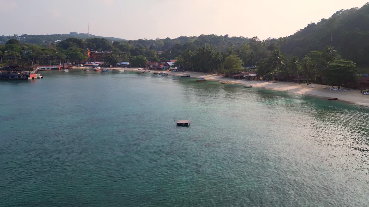 mañana estado de ánimo hermosa vista aérea vuelo de una isla tropical con un largo muelle de madera que conduce a un restaurante flotante, rodeado de aguas turquesas y exuberante bosque tropical verde