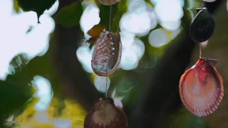 Close-up-of-a-hanging-mobile,-crafted-from-shells-and-seashells-from-the-seaside-moving-in-the-wind