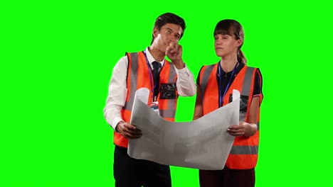 front view of a site workers looking at a site map with green screen