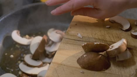 close up of fresh sliced mushrooms being tossed in a cooking pan for a delicious healthy recipe