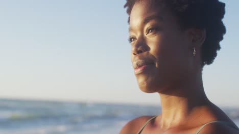 Video-Einer-Afroamerikanischen-Frau,-Die-Bei-Sonnenuntergang-Am-Strand-Steht