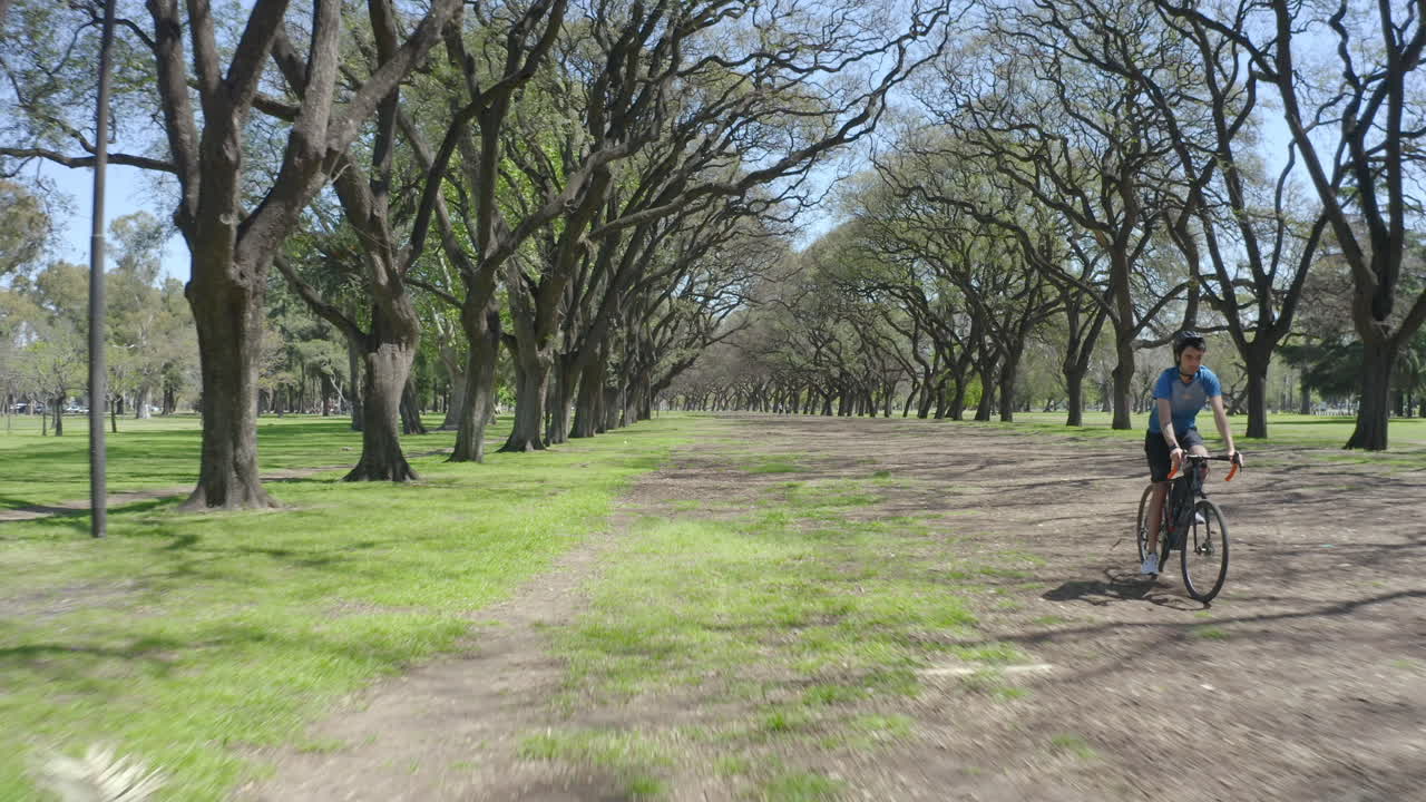 Sportive Man Riding Bike Fast in the Park