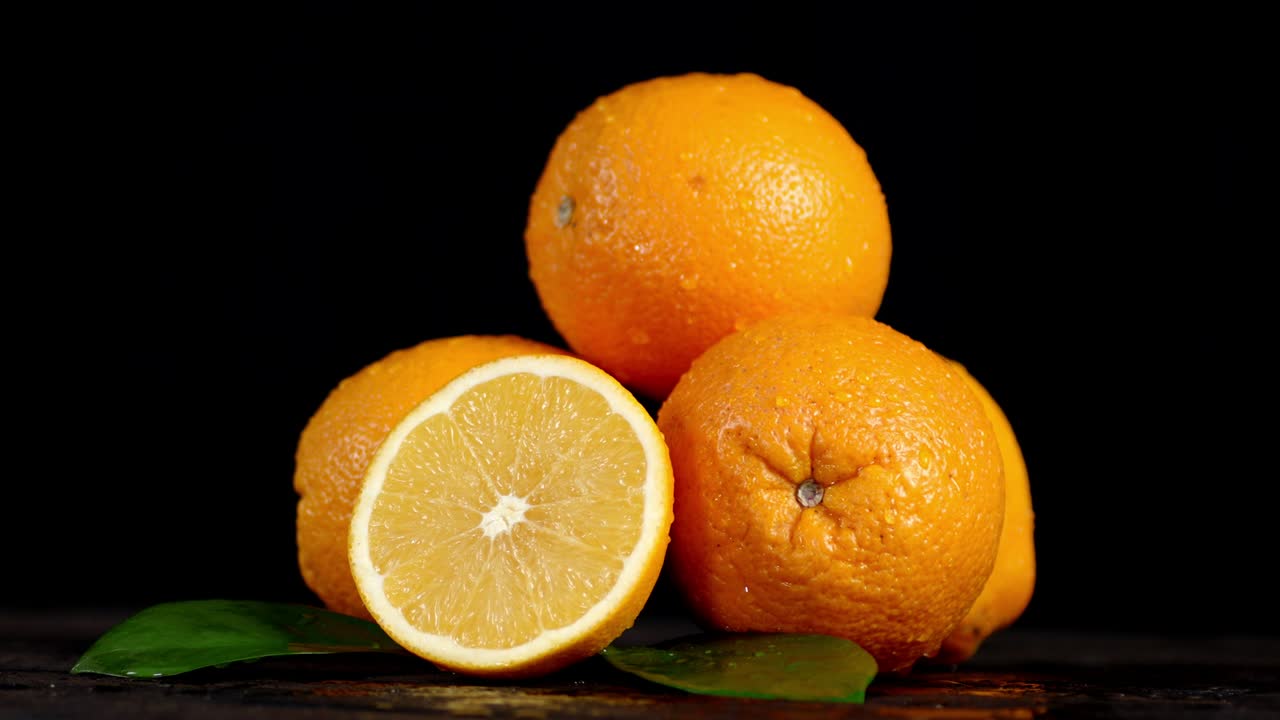 las naranjas jugosas con hojas giran lentamente.