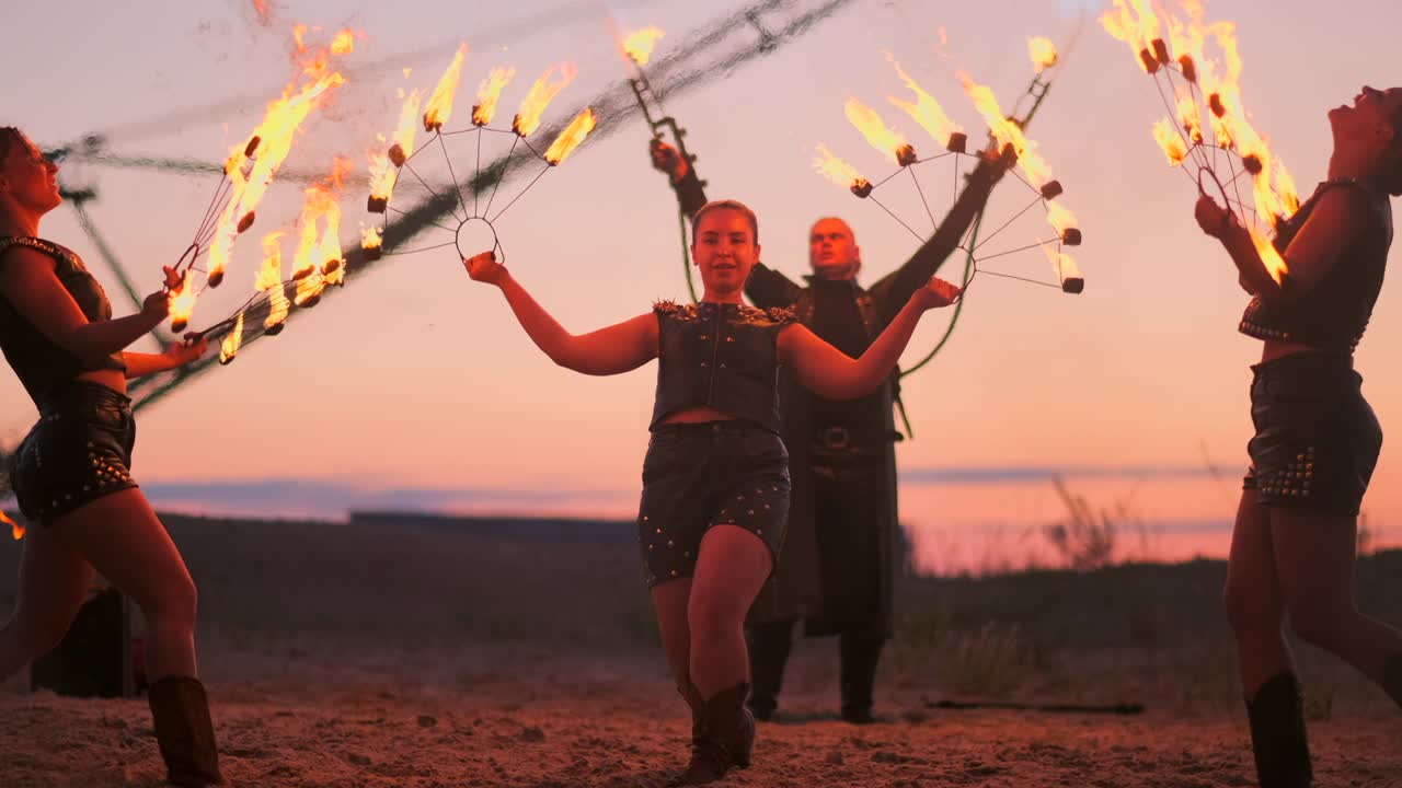 un grupo de artistas profesionales de circo con espectáculos de fuego espectáculos de baile en cámara lenta utilizando lanzallamas y girando las antorchas objetos de quema.