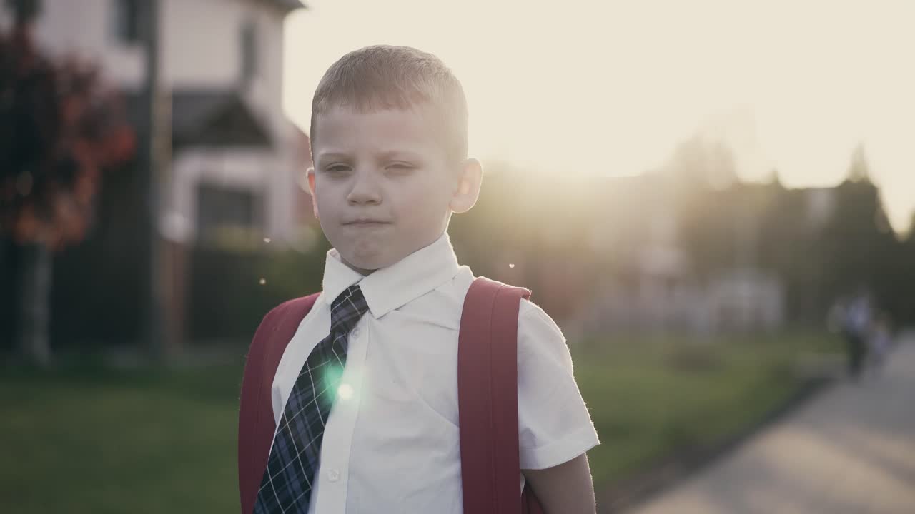 Travelling Portrait CU Schoolboy boy with knapsack behind his back in school uniform He smiles