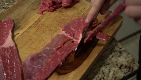 slicing steak on a cutting board in slow motion.