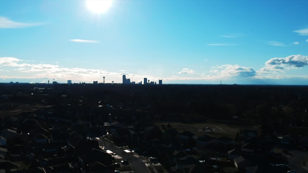 Aerial View of Suburban Houses with Distant City Skyline