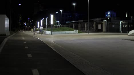 escena nocturna en el parque de la ciudad con personas montando scooters eléctricos