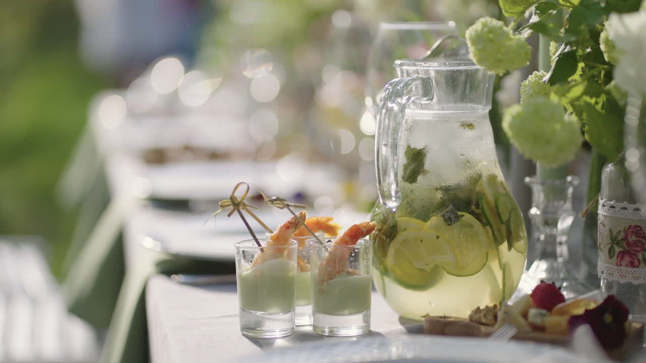 야외 행사를 위한 정원 파티 케이터링에서 식초, 레모네이드 및 꽃이 있는 테이블