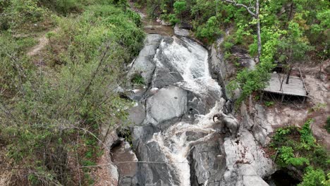 View-From-Above-Of-An-Indian-Elephant-Drinking-Water-From-Flowing-River-In-Chiang-Mai,-Thailand