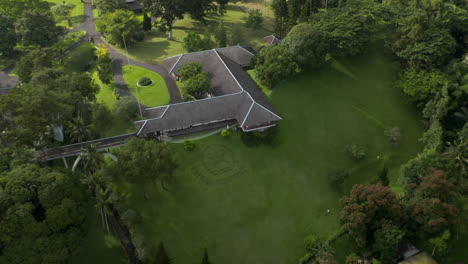 Close-up-aerial-view-circling-around-the-official-seal-on-the-grass-in-front-of-the-Tampaksiring-Presidential-Palace-in-Bali