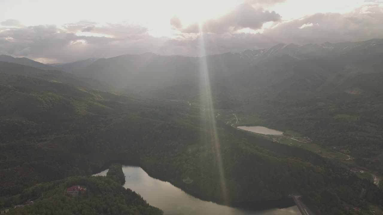 4k cinematic drone stock footage of a beautiful forest in the mountains with a sunset and a lake
