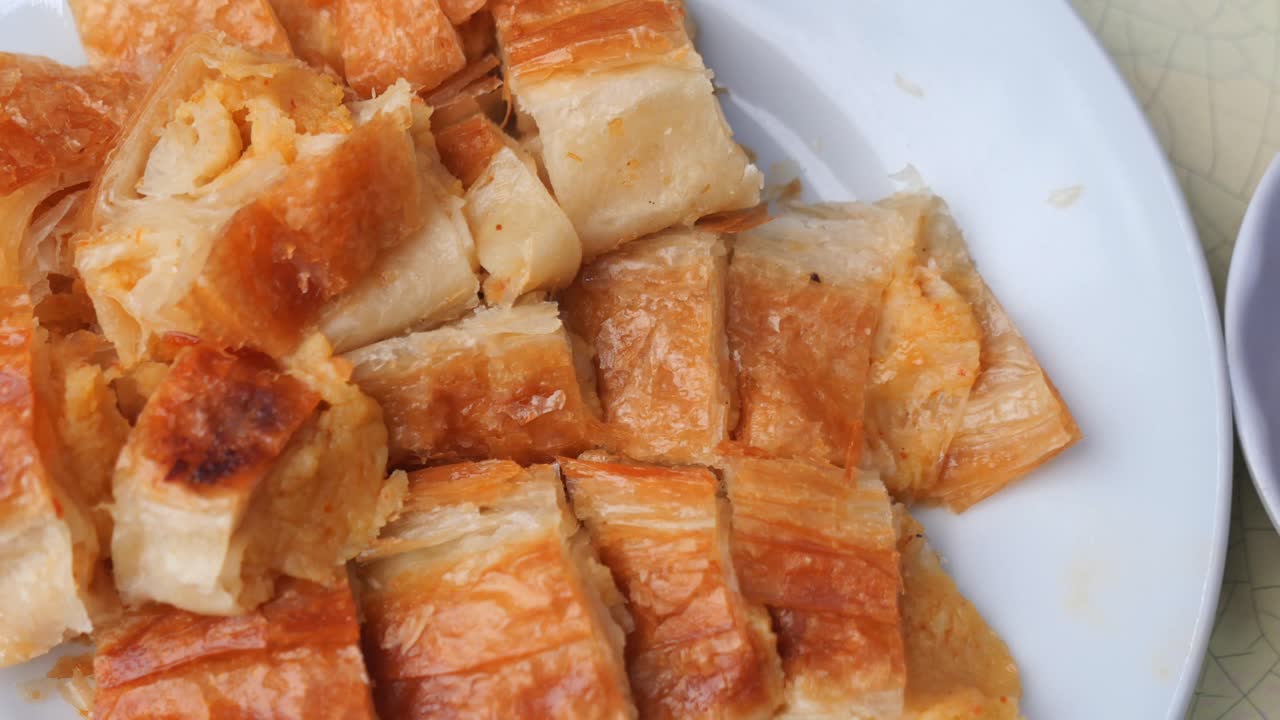 Delizioso börek dorato servito su un piatto bianco con tè