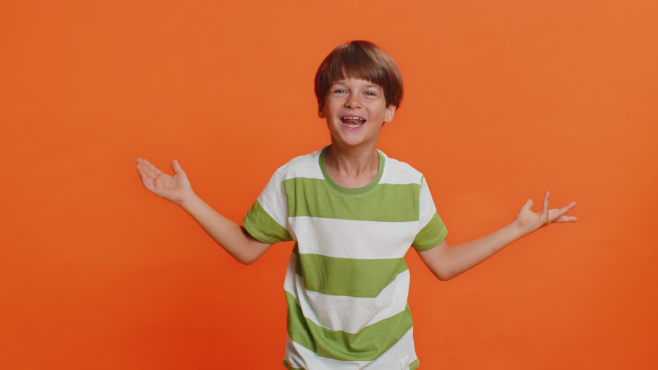 Young cute school boy kid smiling friendly gesturing hello or goodbye welcoming waving hands