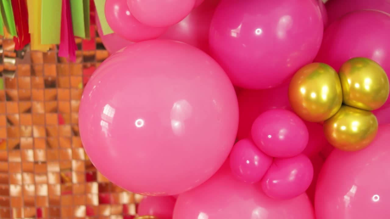 decoración mexicana con globos rosados y dorados con telón de fondo dorado