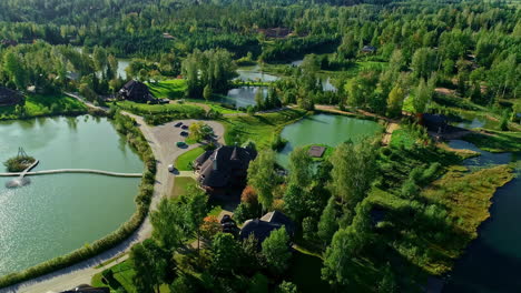 luxury estate surrounded by lakes and forest, aerial orbit view