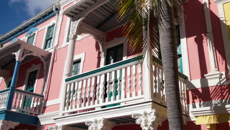 colorful caribbean buildings with balconies and palm trees
