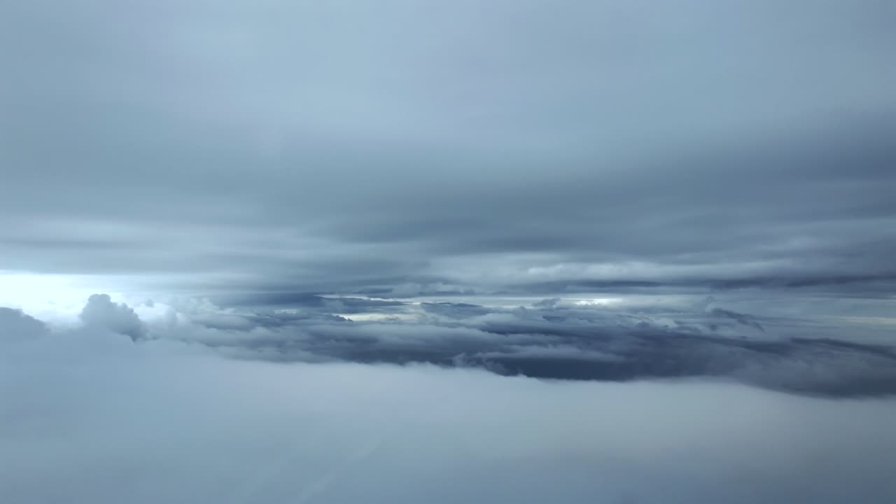 Soğuk bir atmosferde, jet kokpitinden çekilmiş, karlı kış bulutlarının katmanları arasında uçan sürükleyici bir pilot perspektifi