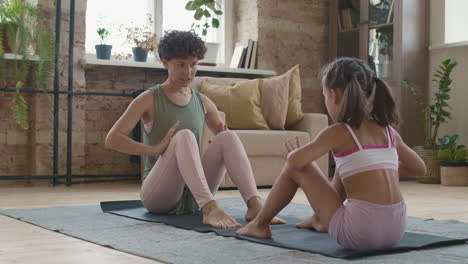 mother and daughter doing yoga together at home