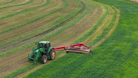 hay harvesting elegance: aerial panorama of a green tractor on a circular field