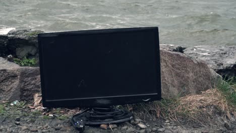 abandoned computer monitor by the river