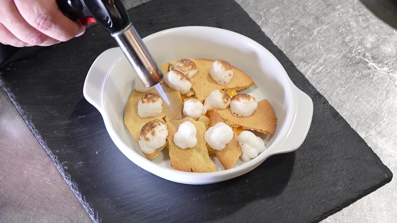 Primo piano dall'alto: Chef che fiammeggia un piatto di mini mozzarelle