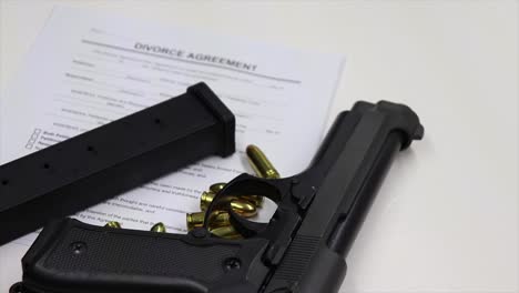 divorce agreement and gun: a representation of conflict