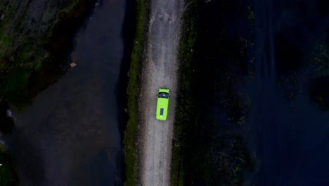 neon van driving on vestrahorn mountains beach road, overhead drone shot
