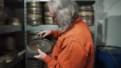 A-man-in-a-film-tape-warehouse-inspects-an-old-film-tape